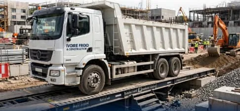 Camion benne en pesée sur un pont bascule, sur un chantier de génie civil
